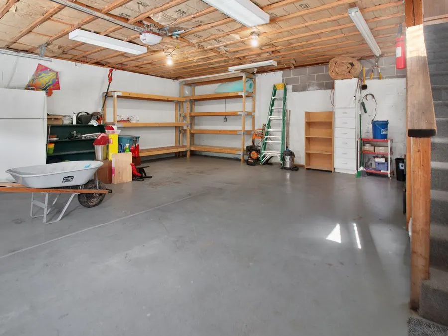 Interior of a home garage with tool storage and shelving along the walls